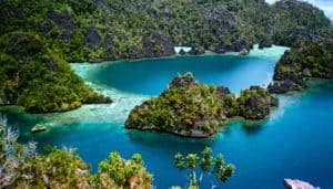 The majestic Puncak Harfat viewpoint offers birds eye views over the mosaic below of limestone towers, lagoons and islets, Raja Ampat